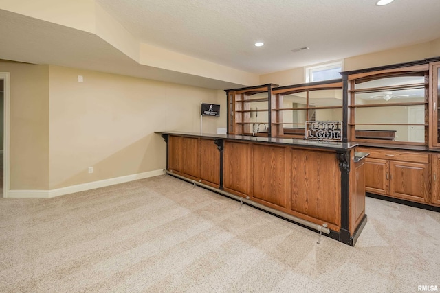 bar with recessed lighting, light colored carpet, baseboards, and a textured ceiling