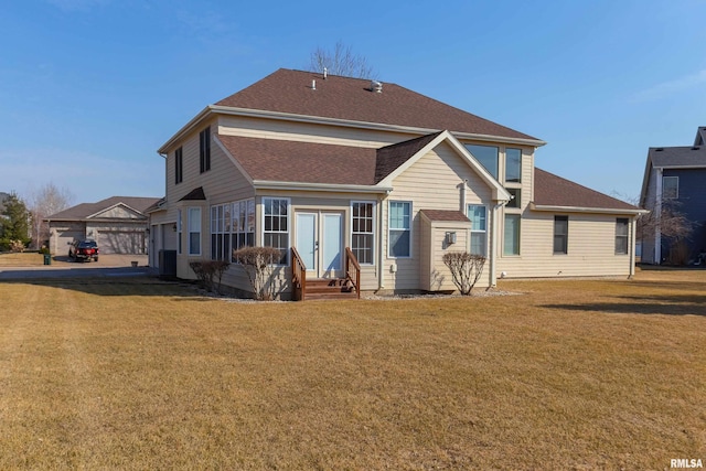 back of house featuring a lawn, entry steps, and a shingled roof