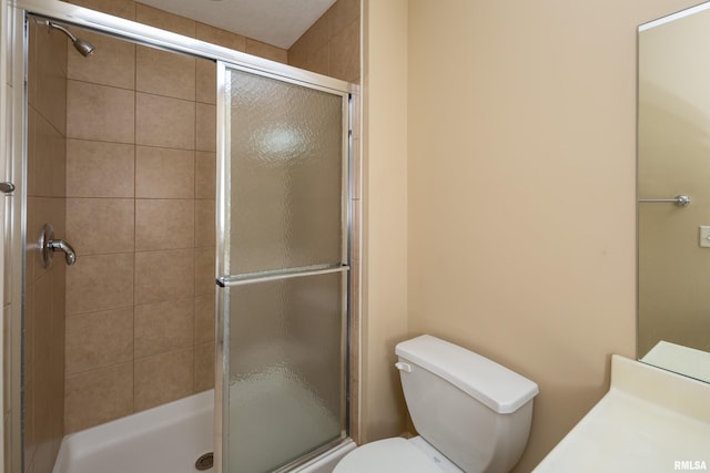 bathroom featuring a stall shower and toilet