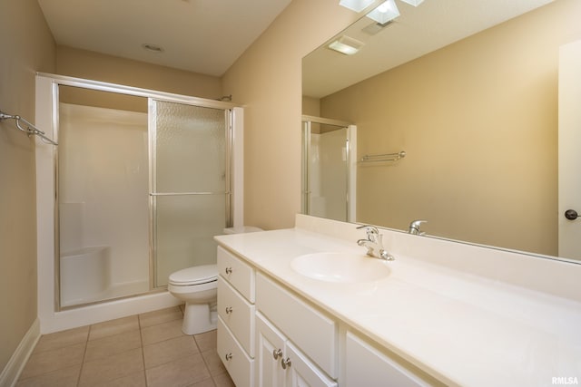 bathroom featuring tile patterned floors, vanity, toilet, and a shower stall