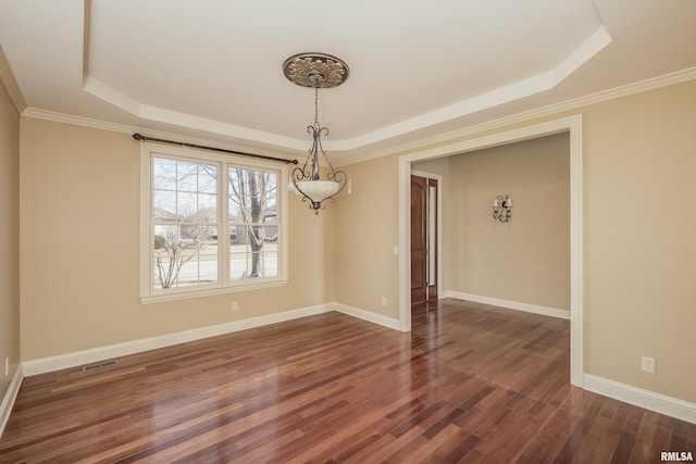 unfurnished dining area with visible vents, a tray ceiling, crown molding, baseboards, and dark wood-style flooring