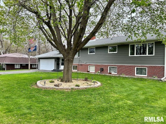 view of front of home with aphalt driveway, a garage, brick siding, and a front yard