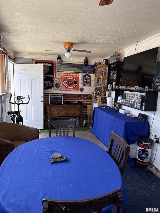 dining area with ceiling fan, carpet floors, and a textured ceiling