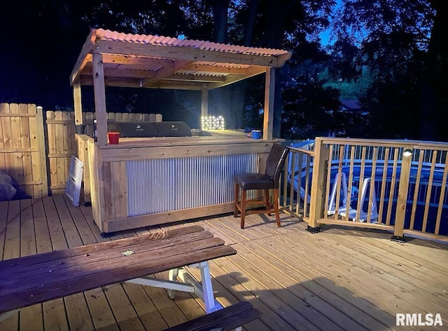 wooden terrace featuring a jacuzzi, a pergola, and fence