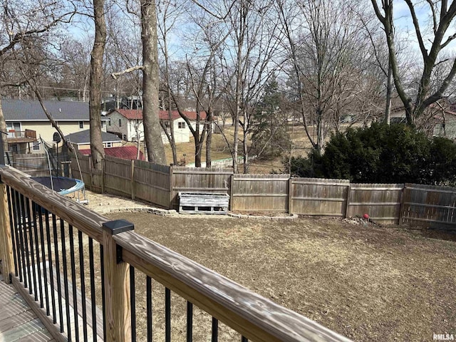 view of yard with a residential view, a trampoline, and a fenced backyard