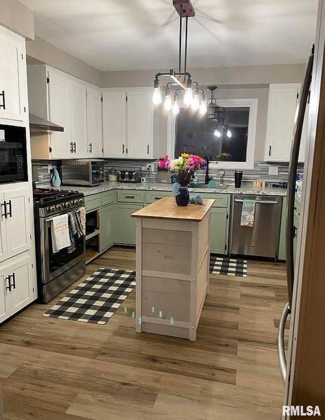 kitchen with backsplash, wood finished floors, white cabinetry, stainless steel appliances, and a toaster