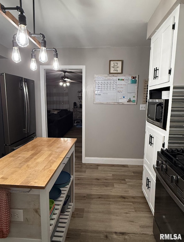 kitchen featuring white cabinetry, black appliances, dark wood finished floors, and wood counters