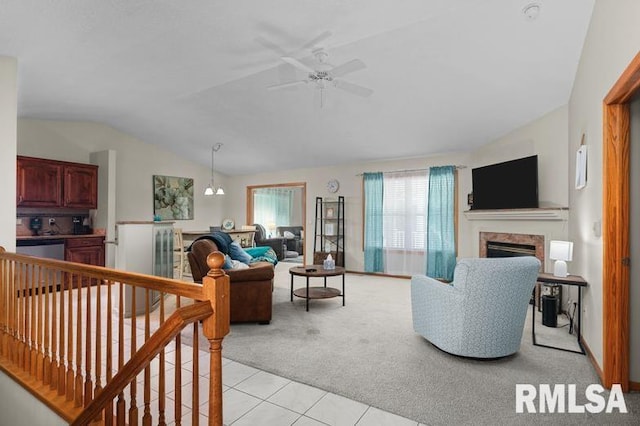 living room with lofted ceiling, light carpet, light tile patterned floors, a fireplace, and a ceiling fan