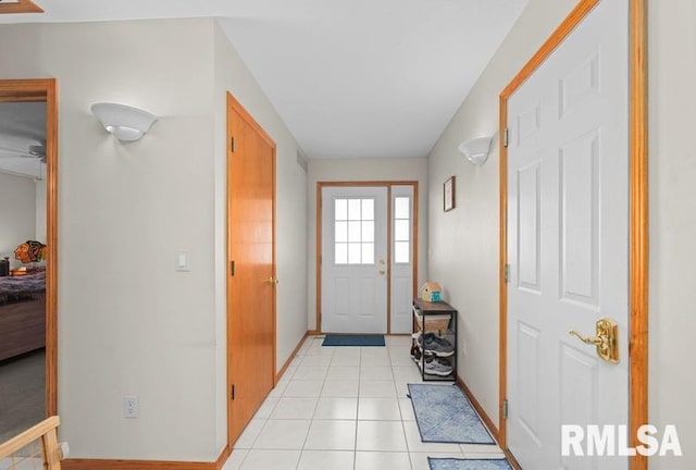 foyer entrance with light tile patterned flooring and baseboards