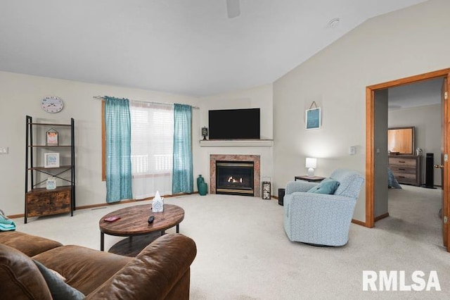 living room with vaulted ceiling, light colored carpet, baseboards, and a lit fireplace