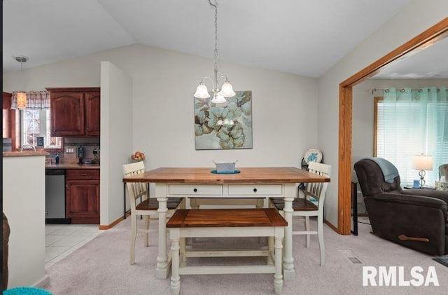 dining room featuring light tile patterned floors, baseboards, lofted ceiling, a notable chandelier, and light colored carpet