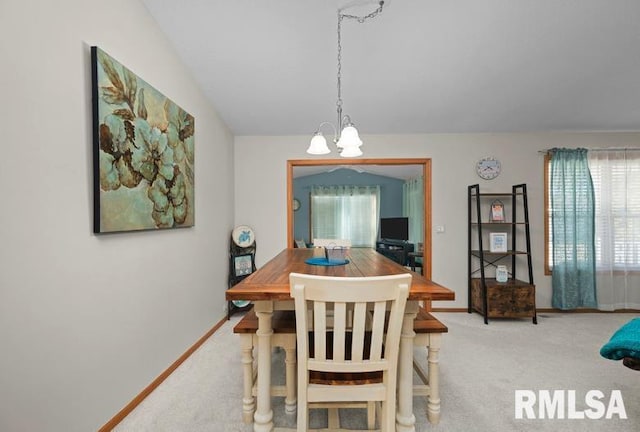 carpeted dining area featuring a notable chandelier and baseboards