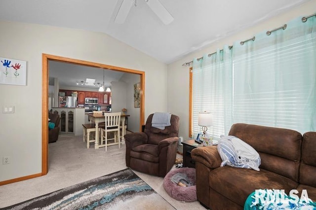 living room with carpet flooring, baseboards, ceiling fan, and vaulted ceiling