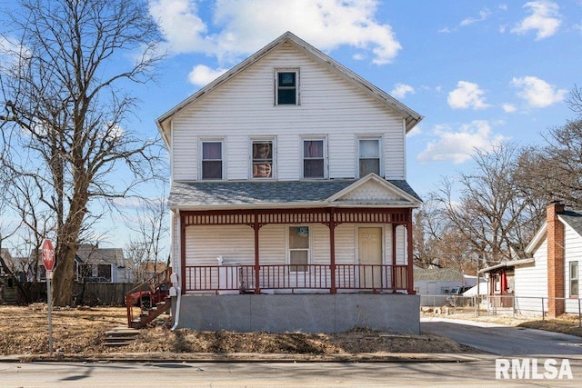 view of front of property with covered porch, a shingled roof, and fence