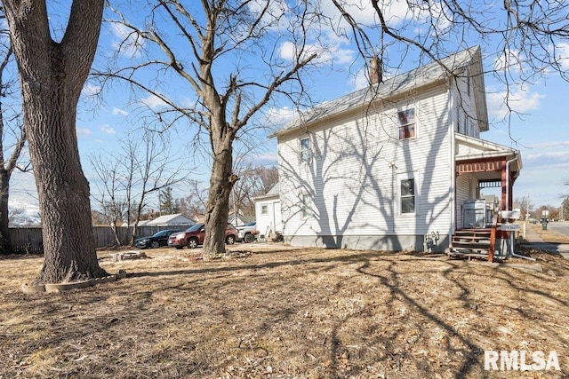 view of home's exterior featuring fence and a chimney