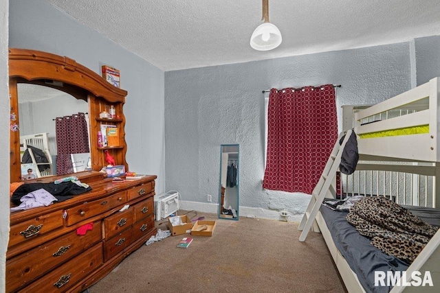 bedroom featuring carpet, a textured wall, baseboards, and a textured ceiling