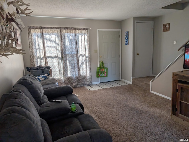 carpeted living room with baseboards and a textured ceiling