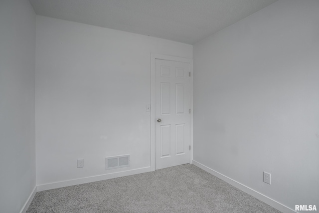 carpeted spare room with baseboards and visible vents