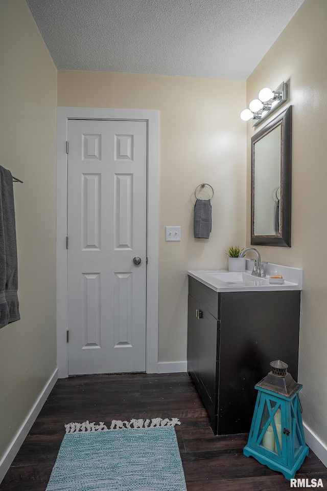 bathroom featuring baseboards, vanity, and wood finished floors