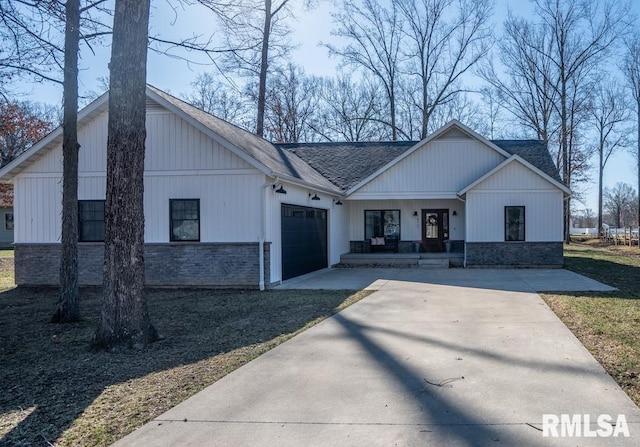 modern farmhouse style home with a shingled roof, covered porch, driveway, stone siding, and an attached garage