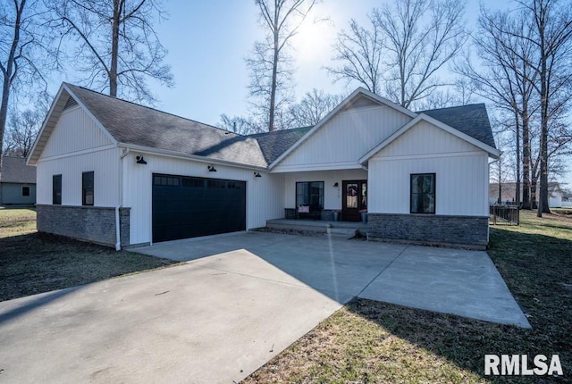 modern farmhouse style home featuring a garage, stone siding, a porch, and concrete driveway