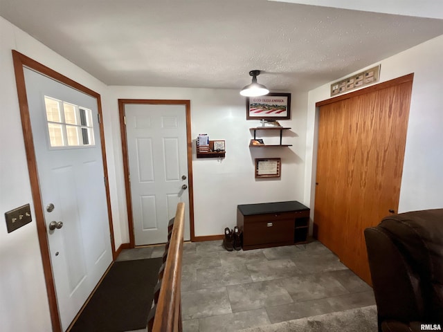 interior space with baseboards and a textured ceiling