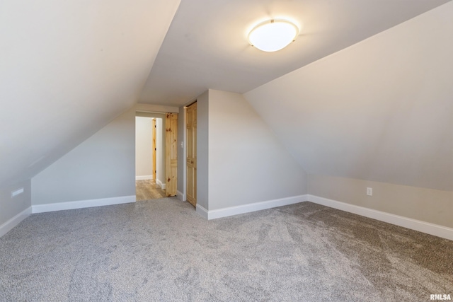 additional living space featuring lofted ceiling, baseboards, and carpet floors