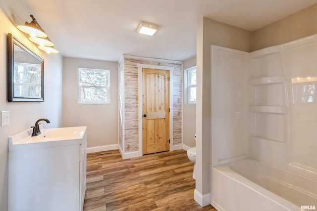 bathroom with baseboards, toilet, wood finished floors, and vanity