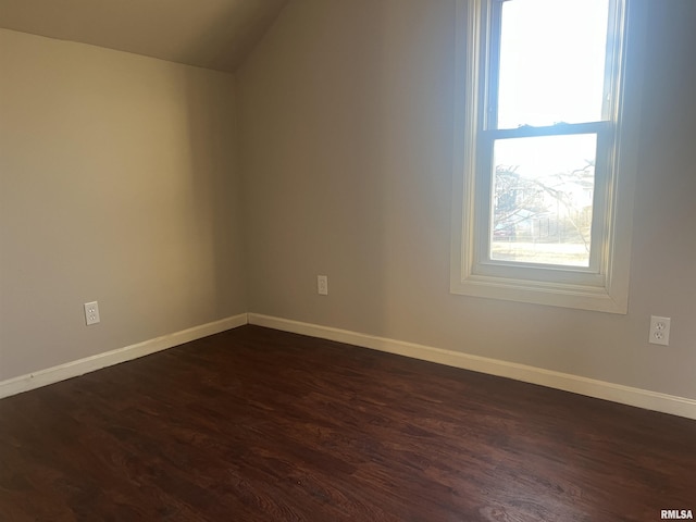 additional living space with baseboards, dark wood-type flooring, and vaulted ceiling