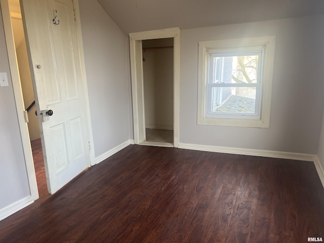 unfurnished bedroom featuring baseboards and dark wood-style flooring