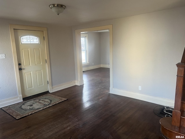 foyer entrance featuring dark wood-type flooring and baseboards