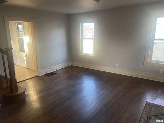 unfurnished room with stairway, baseboards, and hardwood / wood-style flooring