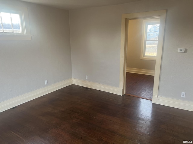 spare room with visible vents, baseboards, and wood finished floors