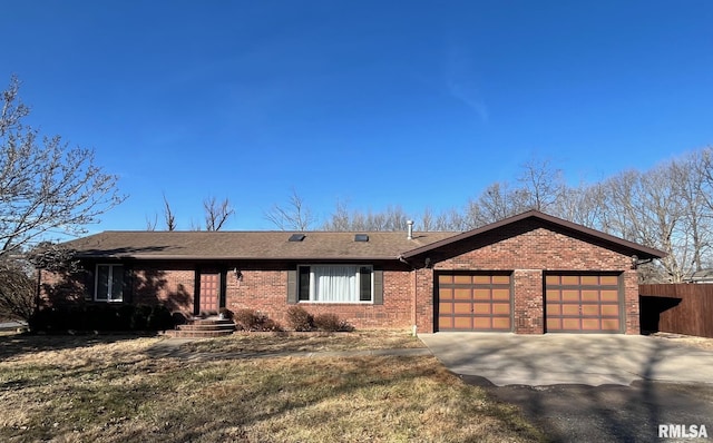 ranch-style house featuring concrete driveway, a garage, fence, and brick siding