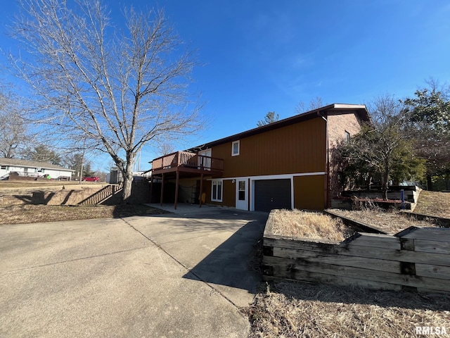 rear view of house with stairway, a deck, and driveway