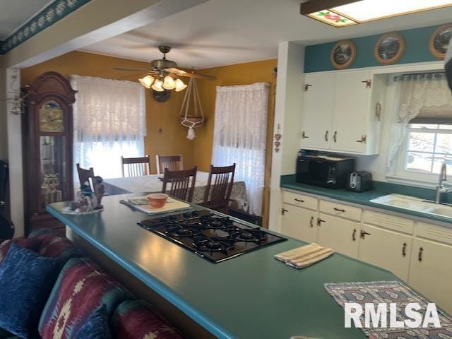 kitchen featuring black appliances, white cabinets, a ceiling fan, and a sink