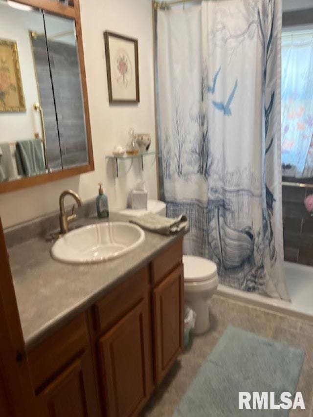 bathroom featuring a shower with curtain, toilet, and vanity