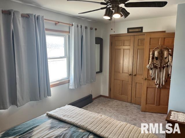 carpeted bedroom with a closet, baseboards, and a ceiling fan