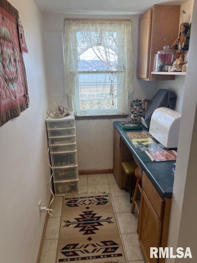 interior space with light tile patterned floors and baseboards