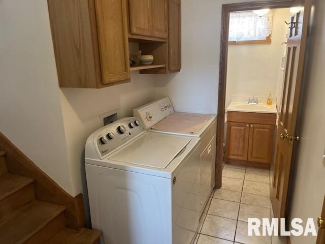 clothes washing area featuring light tile patterned flooring, a sink, cabinet space, and separate washer and dryer