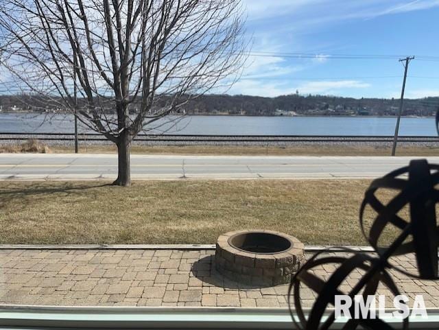 view of yard featuring a fire pit and a water view