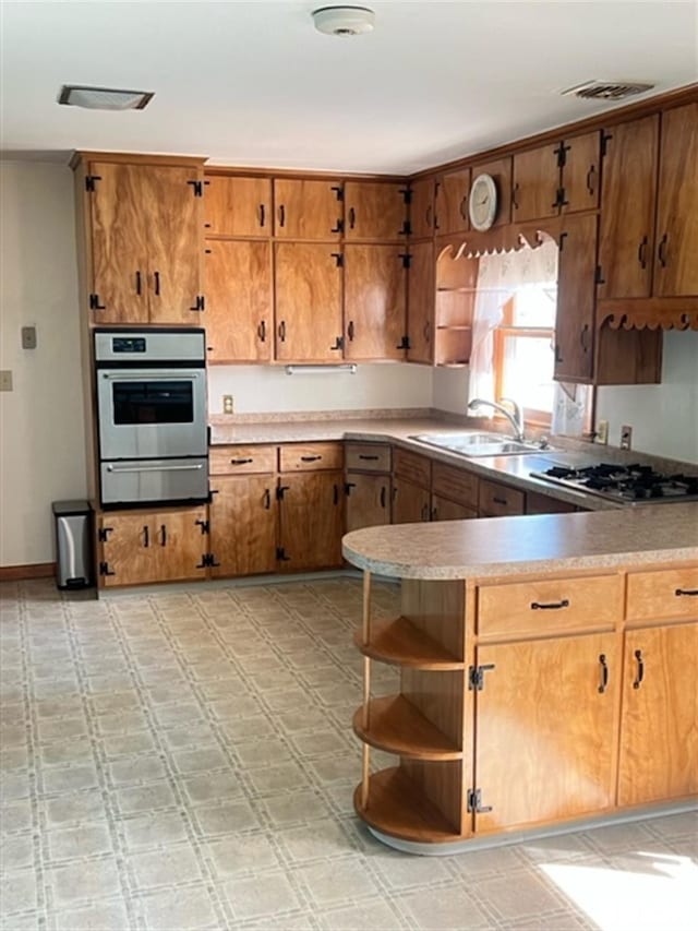 kitchen featuring a sink, light floors, stainless steel appliances, a warming drawer, and open shelves