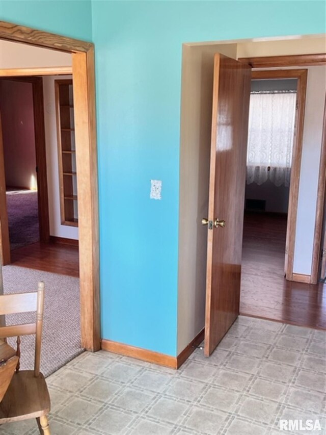 hall featuring baseboards and light wood finished floors