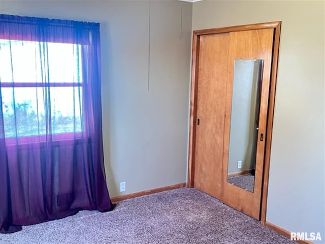 spare room featuring carpet and baseboards