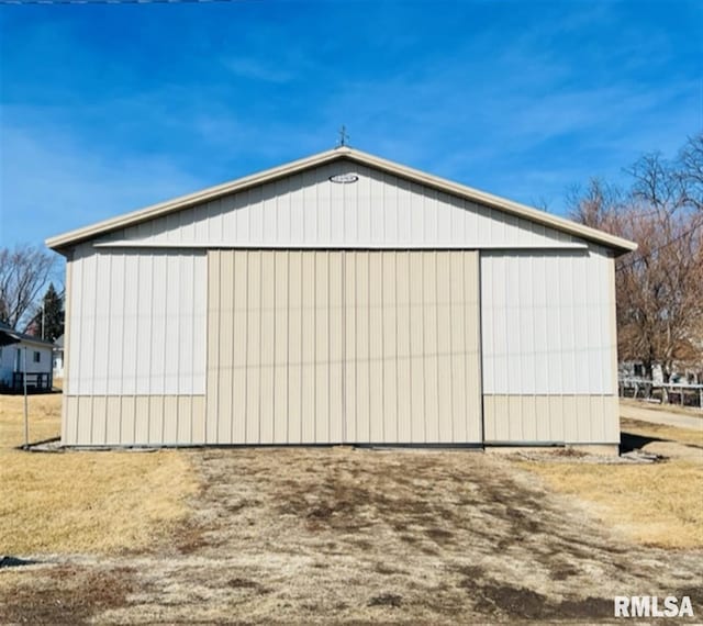 exterior space with a detached garage, an outbuilding, and a pole building