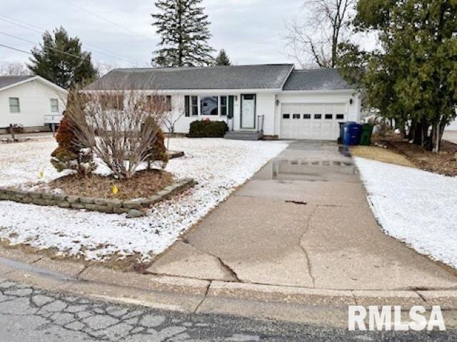 ranch-style home featuring concrete driveway and an attached garage