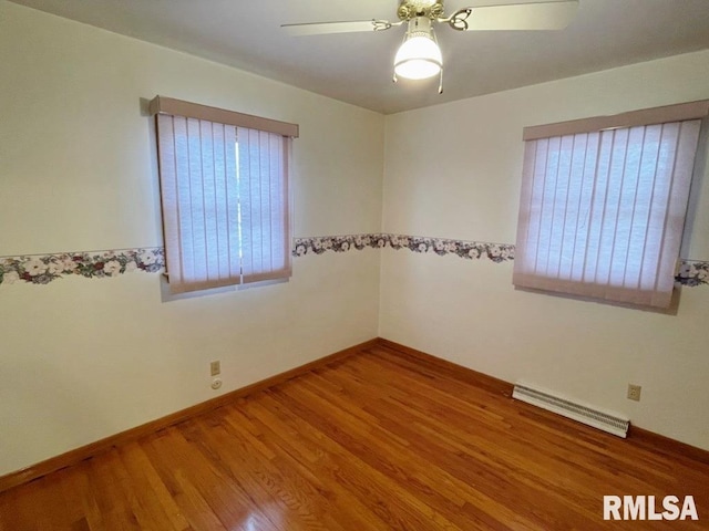 spare room featuring ceiling fan, visible vents, baseboards, and wood finished floors