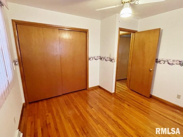 unfurnished bedroom featuring a ceiling fan, light wood-style floors, a closet, and baseboards