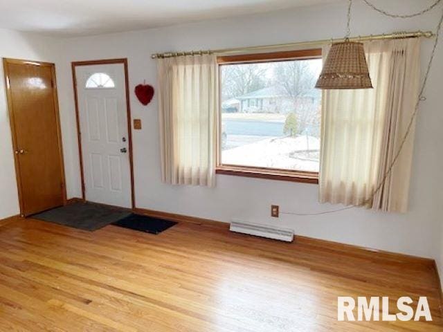foyer entrance featuring light wood-style floors and a baseboard radiator