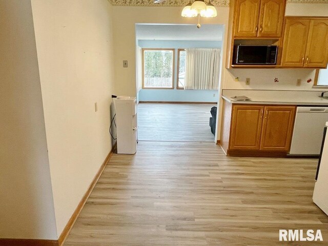 kitchen with light wood finished floors, dishwashing machine, light countertops, and black microwave